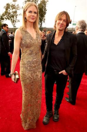 Nicole Kidman y el cantante country Keith Urban en la alfombra roja. Ella optó por un vestido dorado al cuerpo muy elegante. Urban, fiel a su estilo informal, optó por pantalones y borcegos.