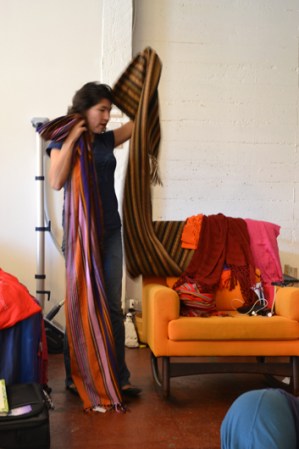 Fabricado con materiales como manta, lana o seda y puede incluir ganchos o aros para facilitar su amarre.