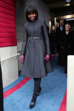 2013. Para la inauguración presidencial actual, la primera dama eligió un original vestido cuadriculado de Tom Brown, lo lució con unas botas negras de Reed Krakoff, complementó su look de invierno con un par de guantes púrpuras y un cinturón de joyas de J.Crew.