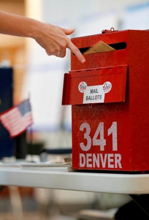 Un votante deposita su voto por correo en Denver, Colorado.