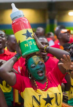 Burkina Faso inspira a las fanáticas. Un biberón gigante sobre la cabeza para alentar a su equipo.