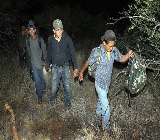SASABE, AZ - JUNE 01: Undocumented immigrants are escorted from their desert hiding spots after entering the country illegally June 1, 2010 near Sasabe, Arizona. They were captured in a group of 10, working their way through the desert at night about two miles north of the border. During the 2009 fiscal year 540,865 undocumented immigrants were apprehended entering the United States illegally along the Mexican border, 241,000 of those were captured in the 262 mile stretch of the border known as the Tucson Sector. (Photo by Scott Olson/Getty Images)