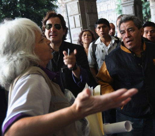 Una supervisora de casilla explica a los votantes que hacen fila cómo iniciar el proceso cuando se abra el centro de votación.