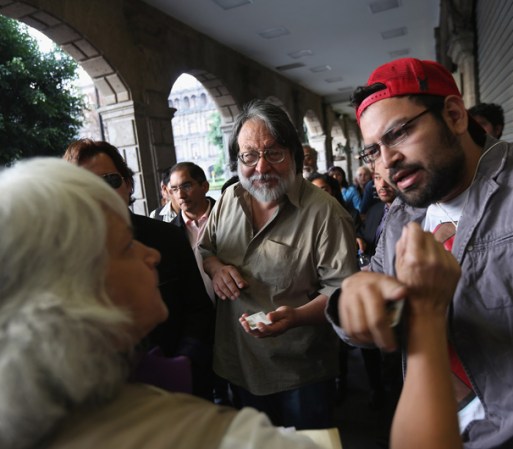 Una supervisora de casilla explica a los votantes que hacen fila cómo iniciar el proceso cuando se abra el centro de votación.