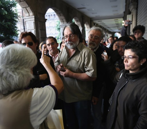 Una supervisora de casilla explica a los votantes que hacen fila cómo iniciar el proceso cuando se abra el centro de votación.