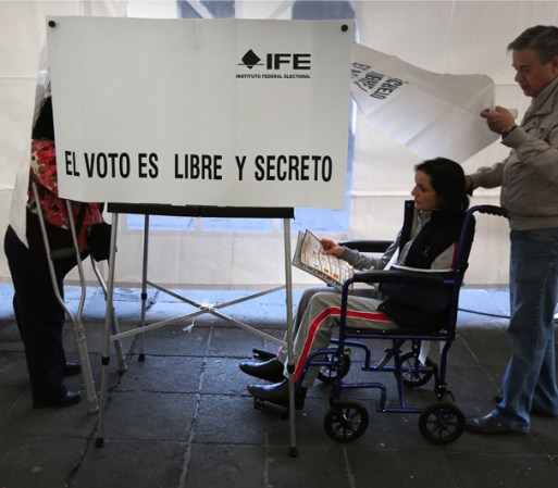 Una mujer con discapacidad llega a votar durante la jornada en la que los mexicanos acudieron a las urnas a escoger a su nuevo Presidente.