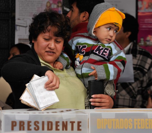 En Atlacomulco, una mujer deposita su voto en la urna.