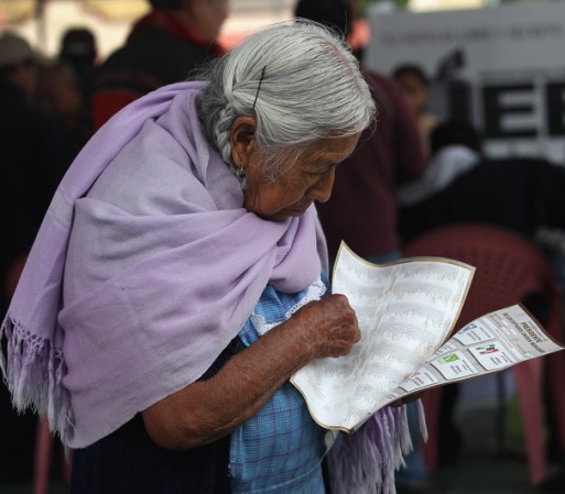 En San Juan, Morelos, una mujer indígena deposita su voto.