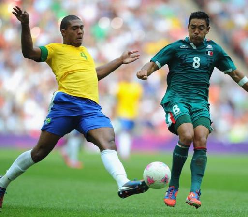 Juan Jesus, de Brasil lucha por el balón con Marco Fabián, de México.