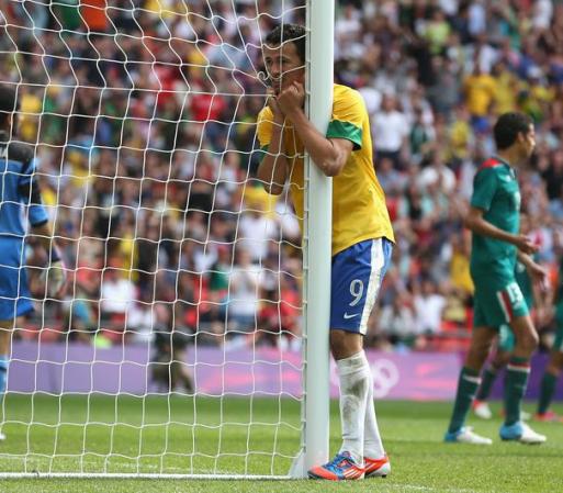 Leandro Damiao, de Brasil abraza la portería cuando Oscar falla lo que pudo haber sido un gol para su equipo.