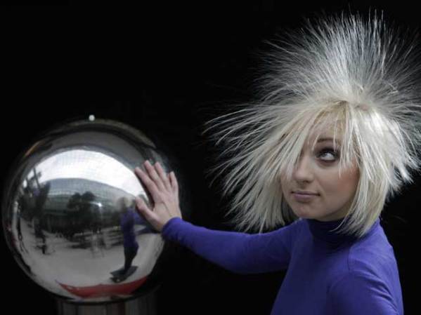 A una modelo se le eriza el pelo al tocar una bola electrificada en una feria de tecnología en Leipzig, Alemania.