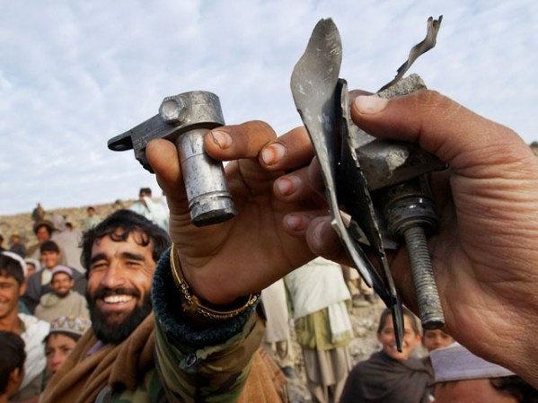 DICIEMBRE, 2001: Afganos muestran restos de las bombas estadounidenses.