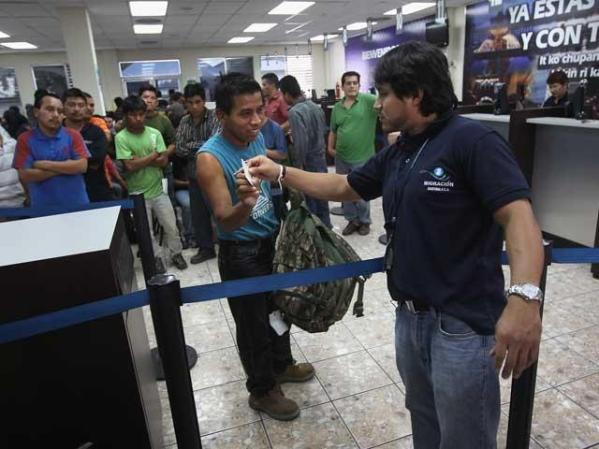 Uno de los deportados recibe sus posesiones, al llegar a Guatemala.