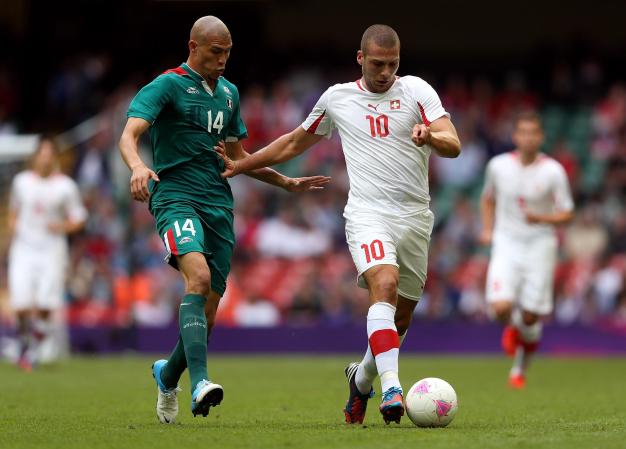 El césped de la cancha del estadio Millennium estaba muy floja por las lluvias de los últimos días. Pajtim Kasami y Jorge Enriquez en una acción del encuentro.