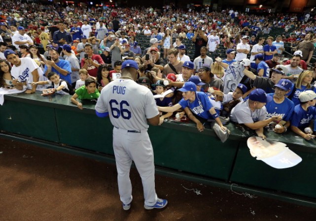 Yasiel Puig #66 de Los Angeles Dodgers firmando autógrafos.