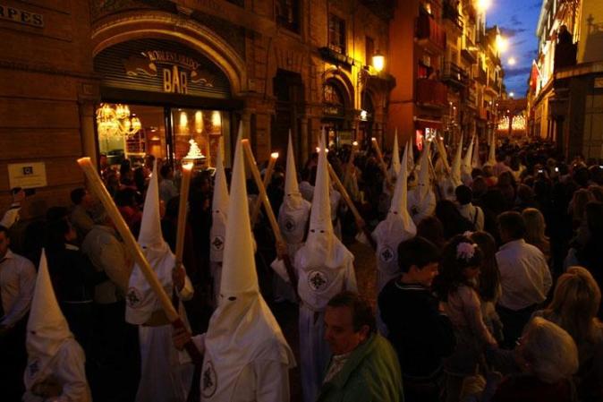 Procesión de la Cofradía de San Gonzálo en Sevilla, España. Los participantes visten los gorros y las túnicas en representación de los nazarenos.