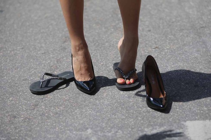 Paola Brogna se pone sus zapatos, mientras se prepara para la carrera del "Tacón de Azúcar", justo antes del inicio.