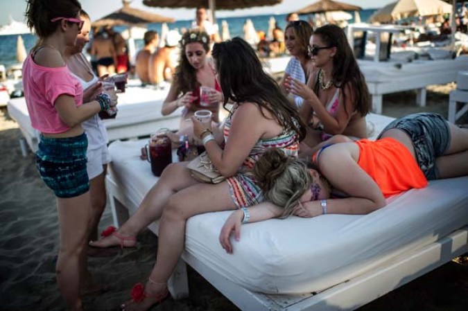 Jóvenes turistas beben sangría en en bar Bora-Bora, en la Platja d'en Bossa.