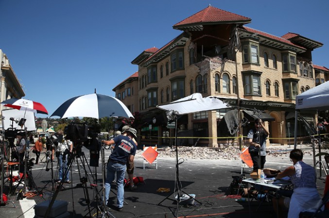 Medios locales se congregan en las afueras de uno de los edificios afectados por el sismo en la Ciudad de Napa.