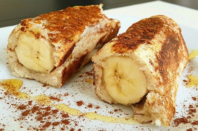 Tostadas francesas con plátano! Se prepara con una clara de huevo, un chorrito de leche de almendras, un sobre de stevia y un toque de canela. Dos rebanadas de pan, sin bordes, se revuelcan en la mezcla y se cubre un plátano. Se fríen y sirven con un toque de miel como topping.