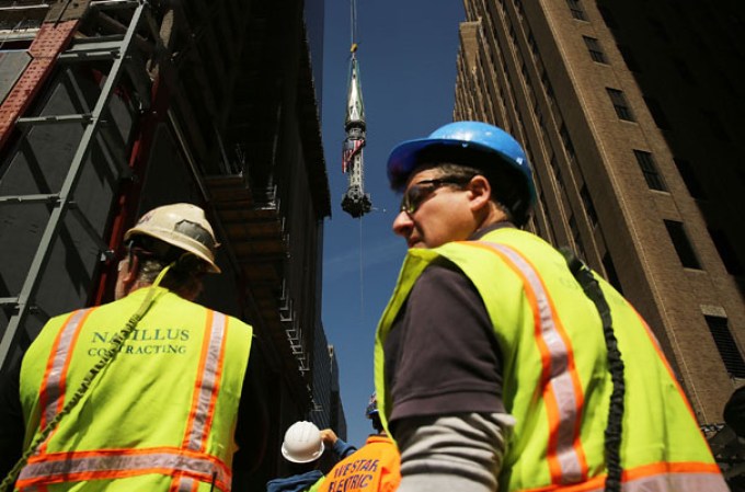 NEW YORK, NY - MAY 02: Construction workers watch as the 408-foot spire is hoisted onto a temporary platform on the top of One World Trade Center on May 2, 2013 in New York City. When bolted into place at a later date, the spire will make One World Trade Center the tallest building in the Western Hemisphere.The raising of the spire, which comes on the second anniversary of the death of Osama bin Laden, will make One World Trade Center 1,776 feet tall. One World Trade Center is built on the site where the September 11, 2001 attacks toppled the original World Trade Center towers. (Photo by Spencer Platt/Getty Images)