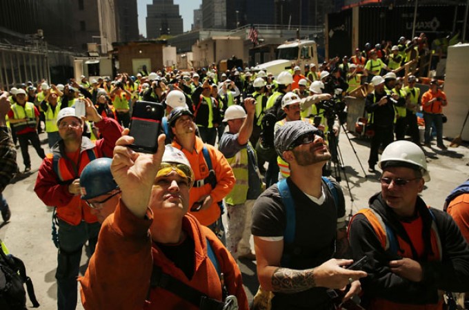 NEW YORK, NY - MAY 02: Construction workers watch as the final two sections of a 408-foot spire are placed on a temporary platform on the top of One World Trade Center on May 2, 2013 in New York City. When bolted into place at a later date, the spire will make One World Trade Center the tallest building in the Western Hemisphere.The raising of the spire, which comes on the second anniversary of the death of Osama bin Laden, will make One World Trade Center 1,776 feet tall. One World Trade Center is built on the site where the September 11, 2001 attacks toppled the original World Trade Center towers. (Photo by Spencer Platt/Getty Images)