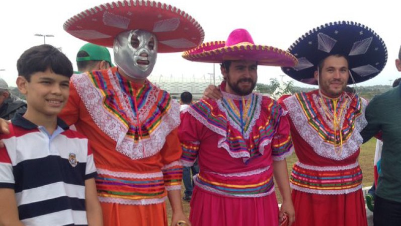Los hombres vestidos con sombrero, máscaras y hasta en vestido de mujer pintan de color la Arena Pernambuco.