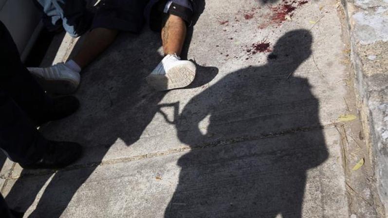 Un militar hace guardia de un cádaver en plena calle.