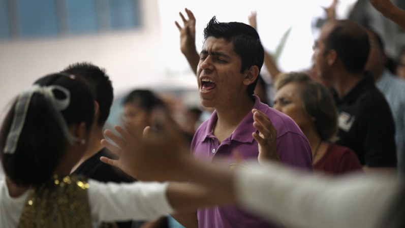 Miembros del grupo evangélico oran en el Centro de la Esperanza y el Amor.