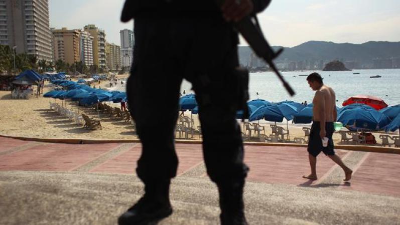 Agente federal hace guardia en un aplaya del paradisicao puerto.