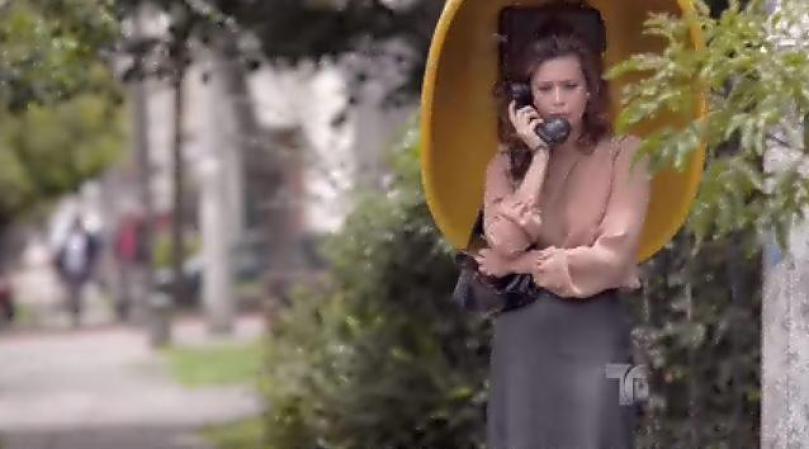Regina se va a un teléfono público a llamarle.