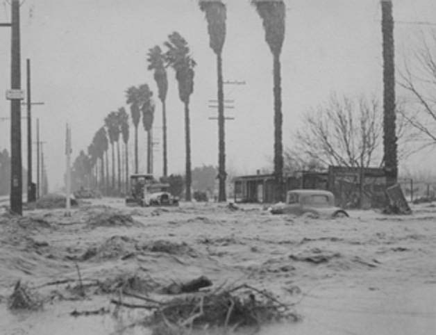 Debris and a few cars can be seen floating on Sherman Way in the San Fernando Valley. This 1938 image was taken from Mason Avenue looking east. The palm fronds indicate a southerly wind.