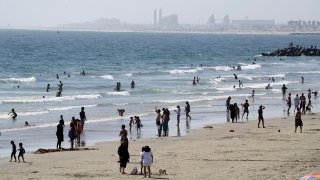 People visit the beach Sunday, May 24, 2020, in Newport Beach, Calif., during the coronavirus pandemic.