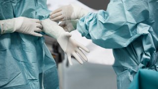 Medical workers putting on gloves