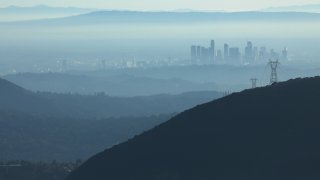 In this Nov. 5, 2019, file photo, the buildings of downtown Los Angeles are partially obscured in the afternoon as seen from near Pasadena, California. The air quality for metropolitan Los Angeles was predicted to be "unhealthy for sensitive groups" by the South Coast Air Quality Management District.