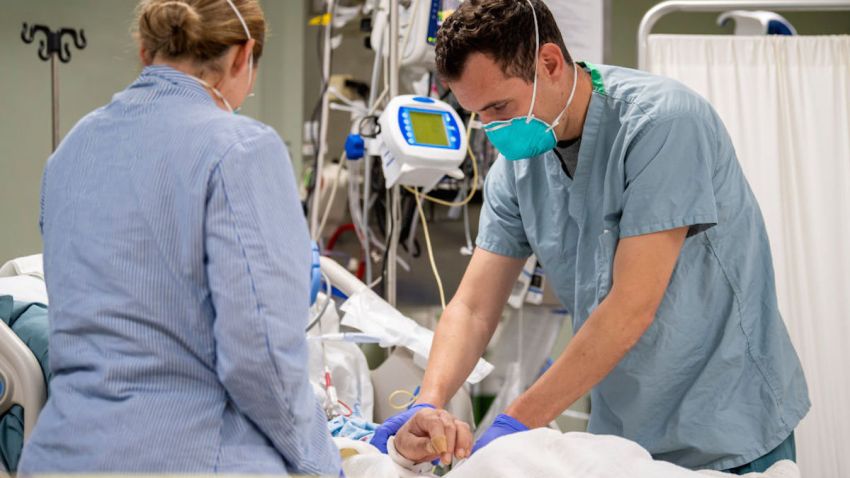 In this April 4, 2020, file photo, Lt. Wade Miller, from Orlando, Fla., treats a patient aboard the hospital ship USNS Mercy.