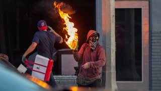 A man throws a molotov cocktail.