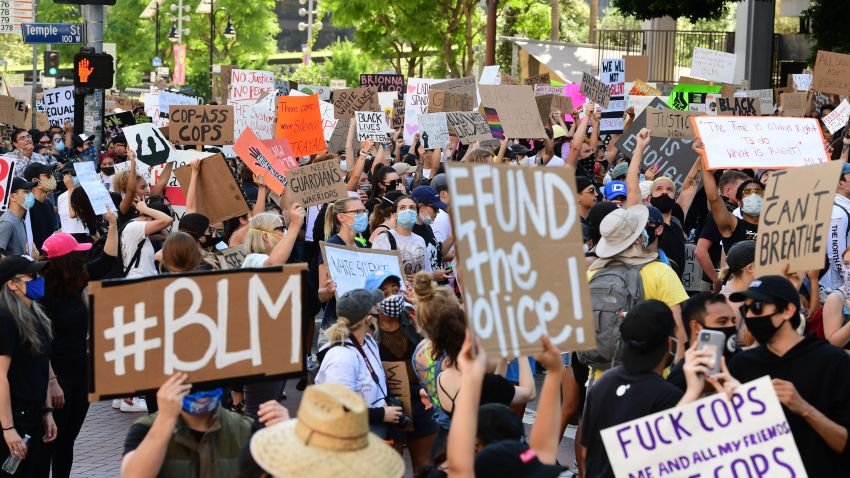 Demonstrators hold signs in front of the District Attorney's office protesting the death of George Floyd, who died in police custody, on June 3, 2020 in Los Angeles.