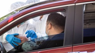 Nurses collect a swab sample from a baby for COVID-19 testing in Baldwin Park, Calif., on April 14, 2020.