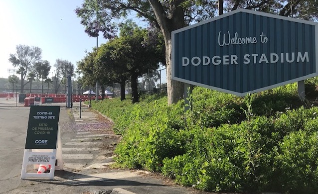 Dodger Stadium's entrance has a sign indicating coronavirus testing is available.