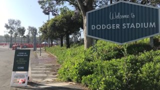 Dodger Stadium's entrance has a sign indicating coronavirus testing is available.