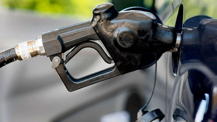 File photo of a gas pump in a vehicle.