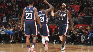 Three Clippers basketball players on a court during a game