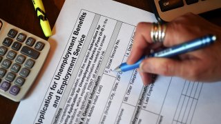 In this April 16, 2020, photo illustration, a person files an application for unemployment benefits in Arlington, Virginia.