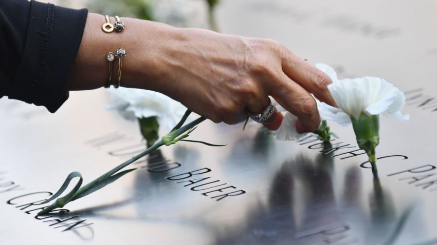 A mourner places flowers at the 9/11 Memorial Museum in New York on September 11, 2020, as the US commemorates the 19th anniversary of the 9/11 attacks.