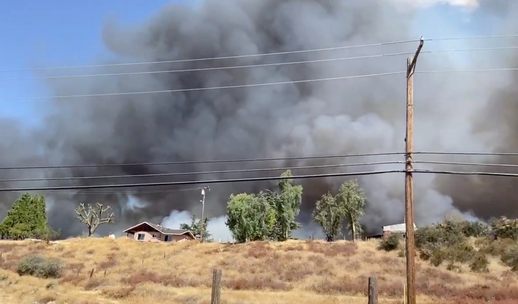 Smoke rises behind homes.