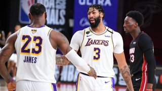 In this Oct. 11, 2020, file photo, LeBron James #23 of the Los Angeles Lakers and Anthony Davis #3 of the Los Angeles Lakers high five during the game against the Miami Heat during Game Six of the NBA Finals at The AdventHealth Arena at ESPN Wide World Of Sports Complex in Orlando, Florida.