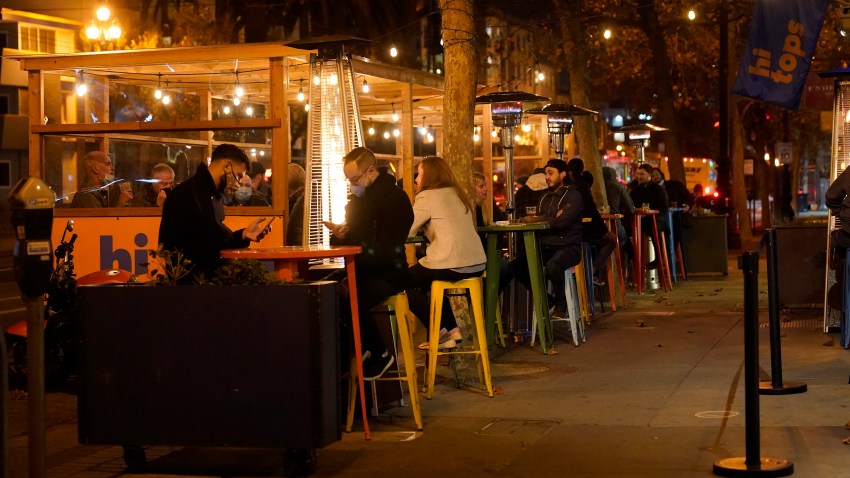 People sit in an outdoor dining area on Market Street amid the coronavirus outbreak in San Francisco, Tuesday, Nov. 24, 2020.