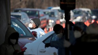 Workers test residents at a drive-up COVID-19 test site on November 13, 2020 in Aurora, Illinois.