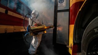 Un hombre desinfecta autobuses en Tijuana